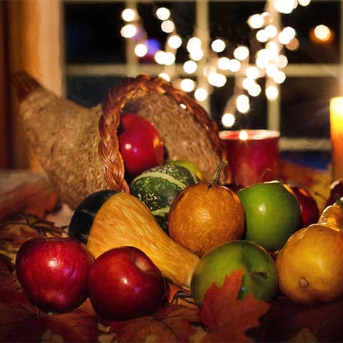 A cornucopia of fruits and vegetables to show a traditional tablescape for Thanksgiving.