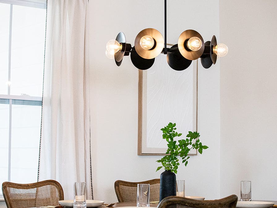 Fernando chandelier in a matte black finish above a dining table.