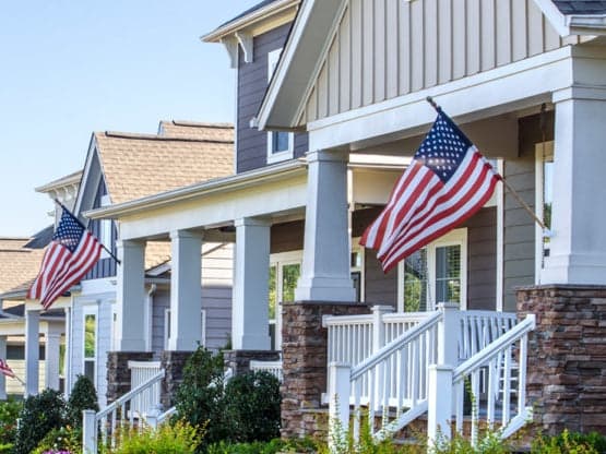 row of homes displaying the american flag to support our military