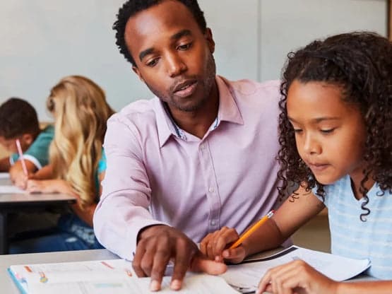 Student and teacher reviewing classwork at a desk