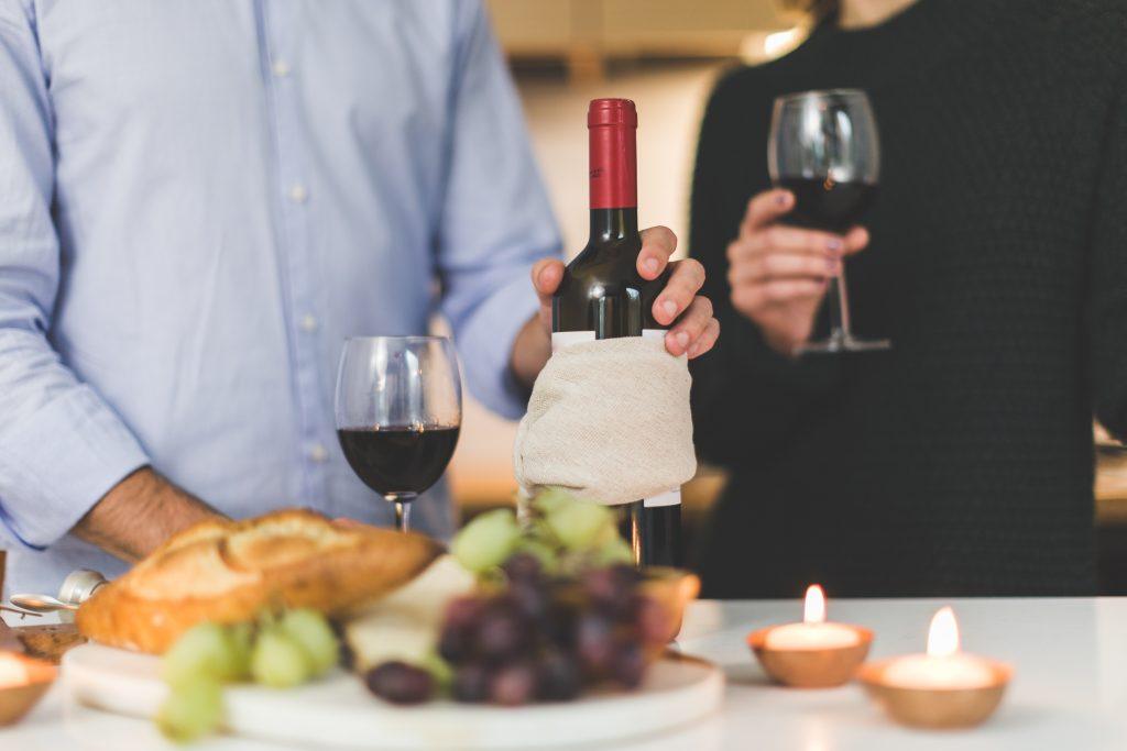 Couple getting pouring some glasses of wine and getting ready for a date night