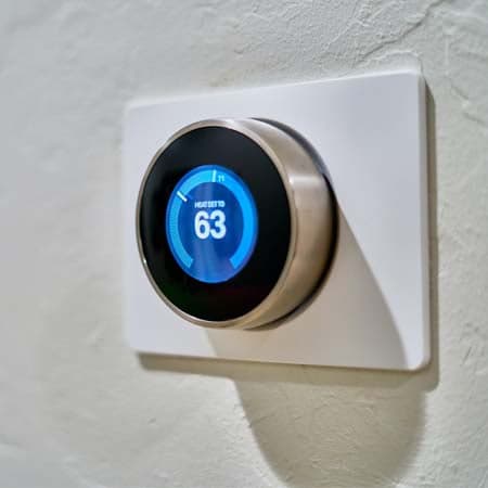 Image of a thermostat being at 63 degrees Fahrenheit