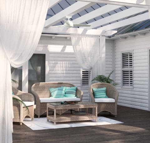Trimaran outdoor fan in Fresh White hanging from a pergola on an outdoor patio.