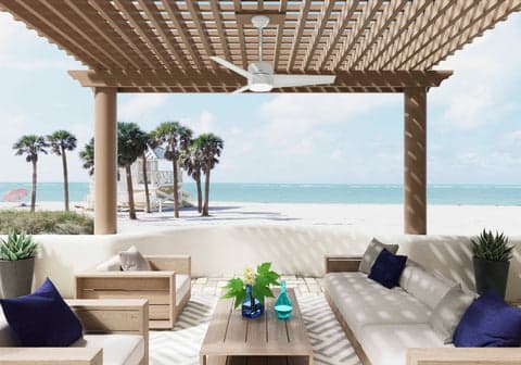 Havoc outdoor fan in Fresh White hanging on a Pergola on the beach.