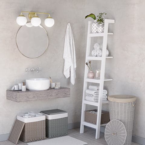 Hepburn 3 Light Vanity in Modern Brass hanging above a mirror and bathroom sink