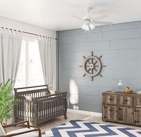 Swanson fan in Matte White hanging above a wooden crib in a neutral nursery