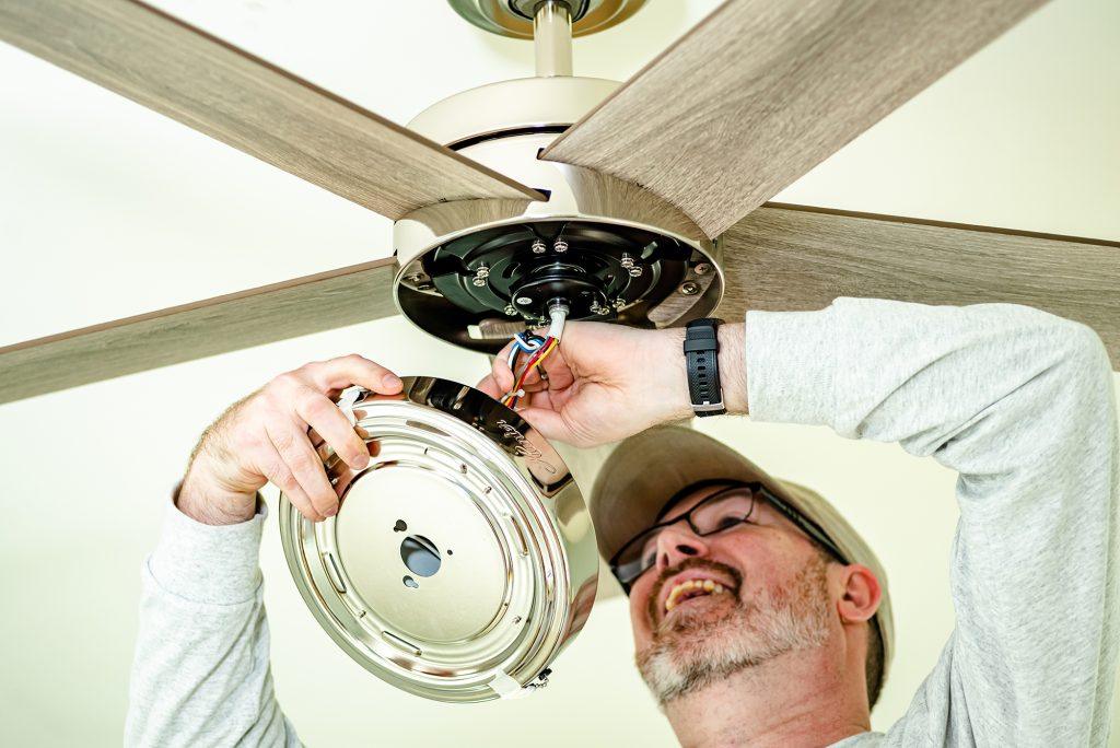 Hunter Fan Company employee installing a ceiling fan during Dorothy Day House of Memphis Huntervention
