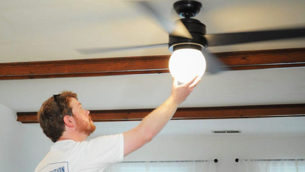 Man installing light on a ceiling fan